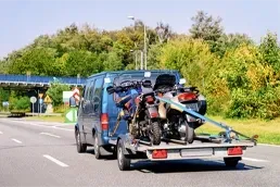 Motorcycle Towing Service Transporting Bike on Trailer Tow truck transporting motorcycle on trailer for professional motorcycle towing service