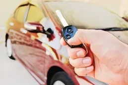 Driver using remote key while locked out of car needing professional roadside lockout service