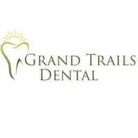 Grand Trails Dental logo featuring a stylized green tooth outline with a rising sun above it and the clinic name in green serif lettering.