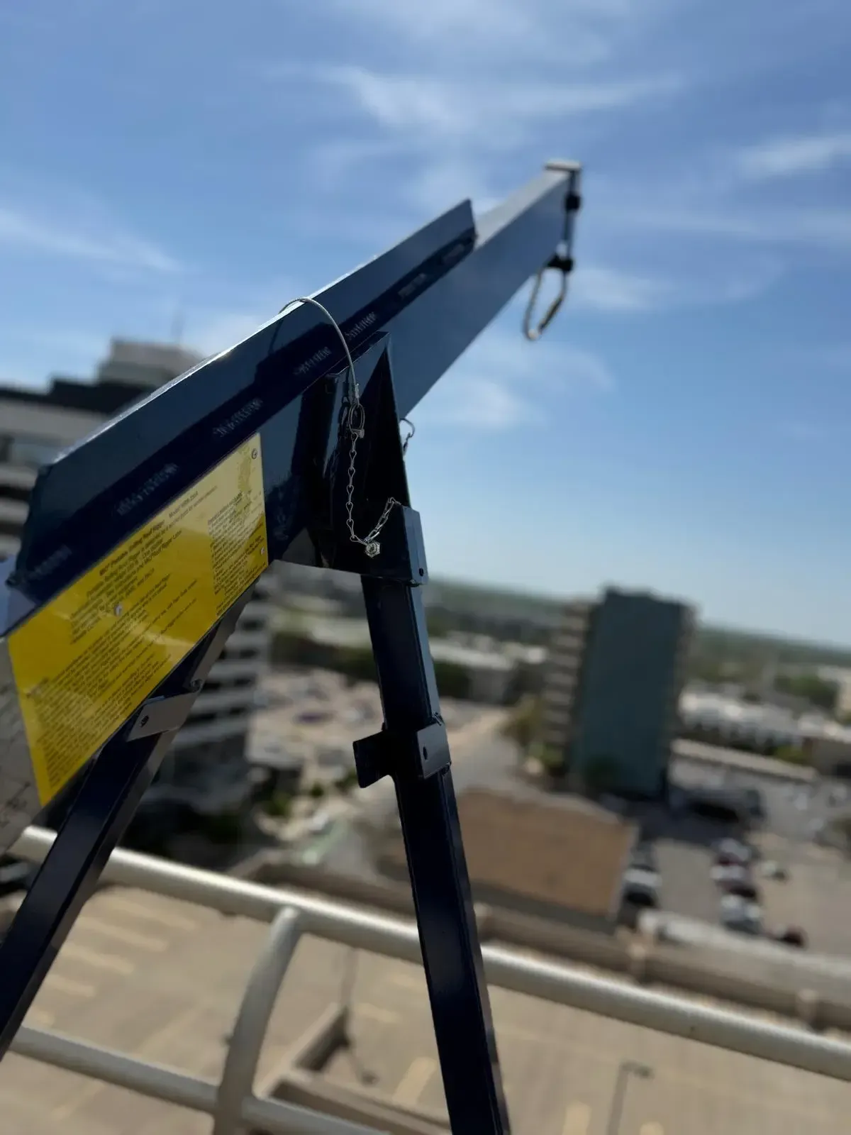 Professional window cleaning squeegee equipment on high-rise building balcony with Oklahoma City skyline in background - SudsMonkey Window Cleaning commercial services