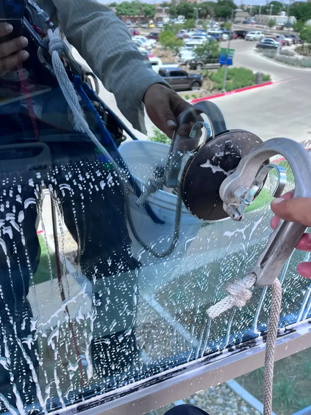 Professional window cleaner using squeegee on high-rise building windows