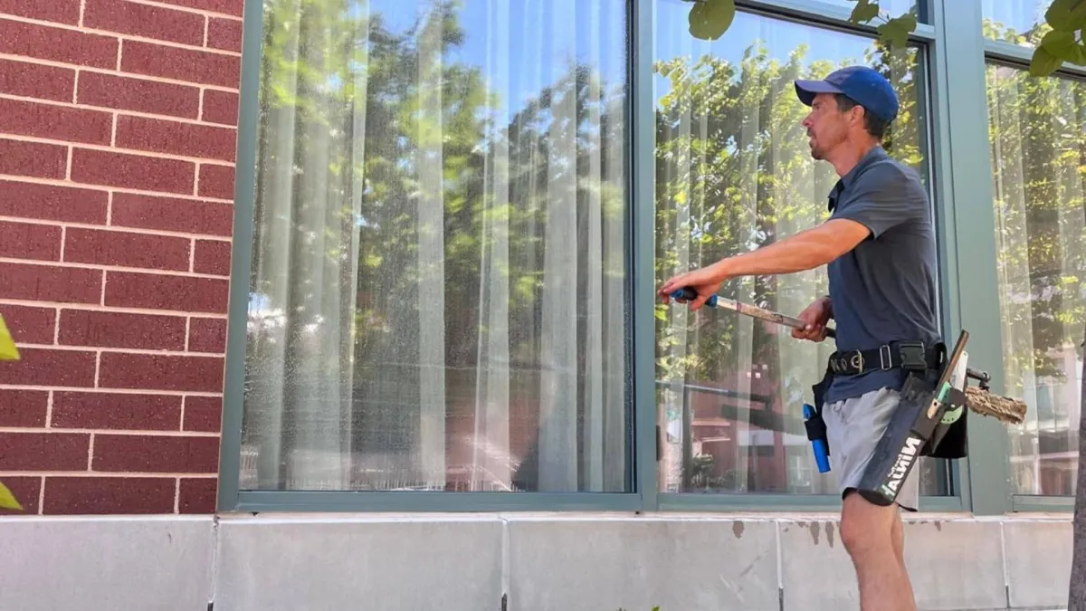 Oklahoma City window cleaner professionally cleaning residential windows with squeegee
