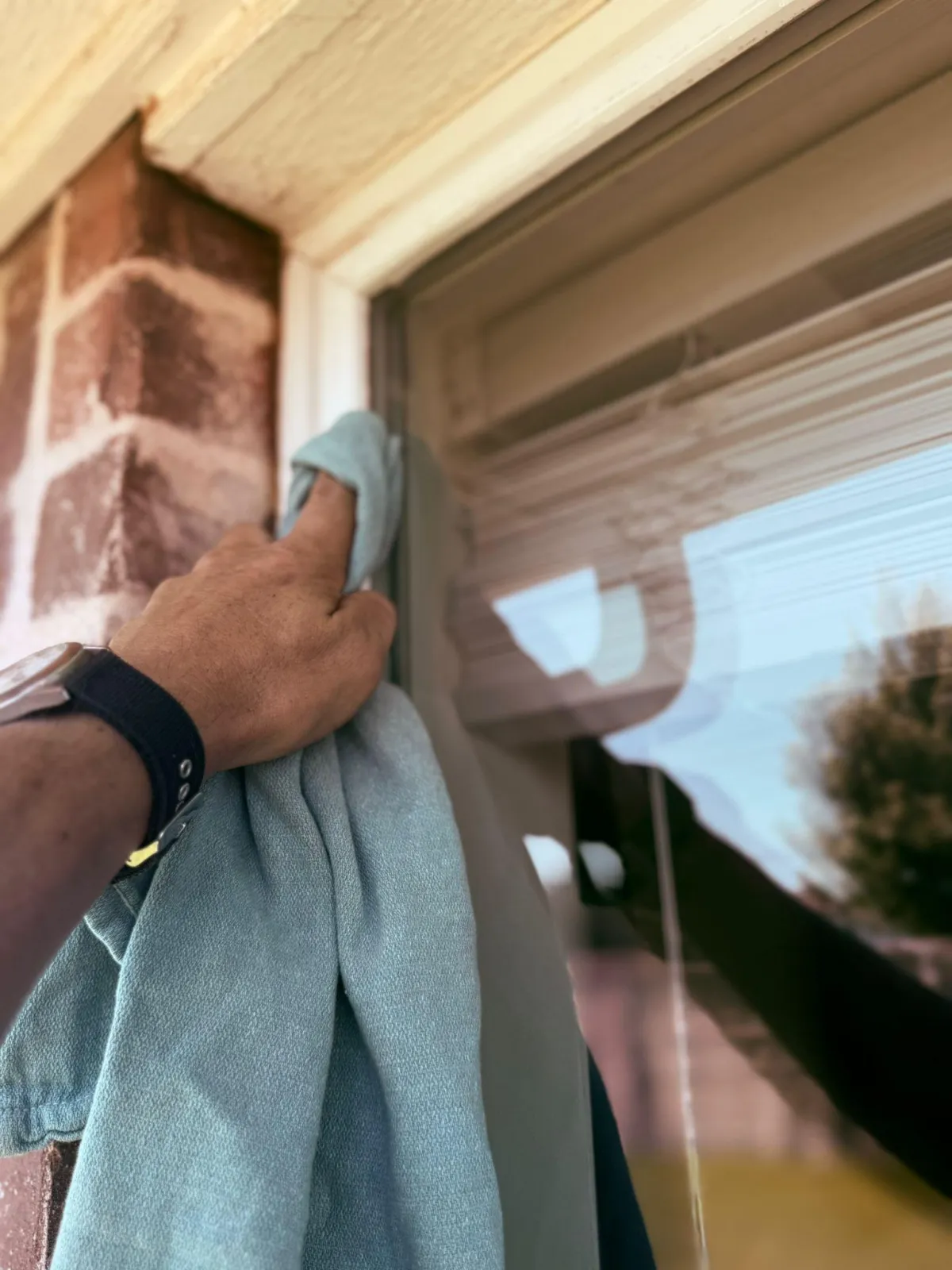 Oklahoma City window cleaner professionally cleaning residential windows with squeegee