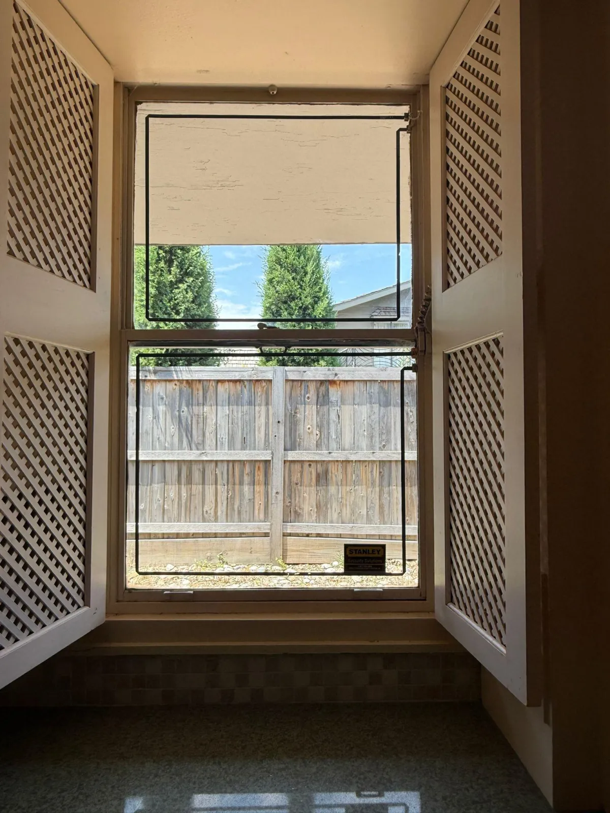 Oklahoma City window cleaning technician safely cleaning multi-story home windows with professional ladder equipmen