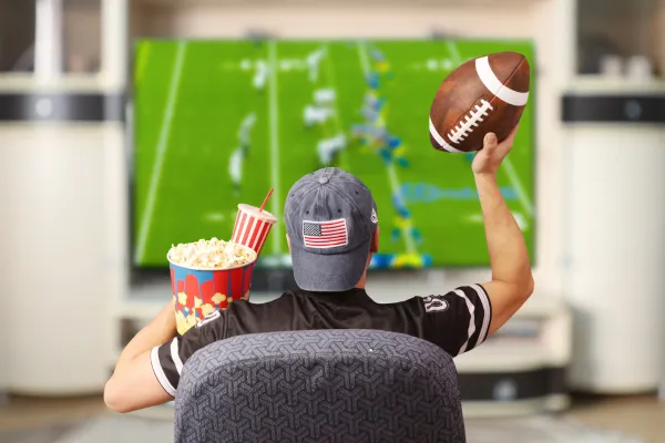 Packed American football stadium with cheering fans under bright lights