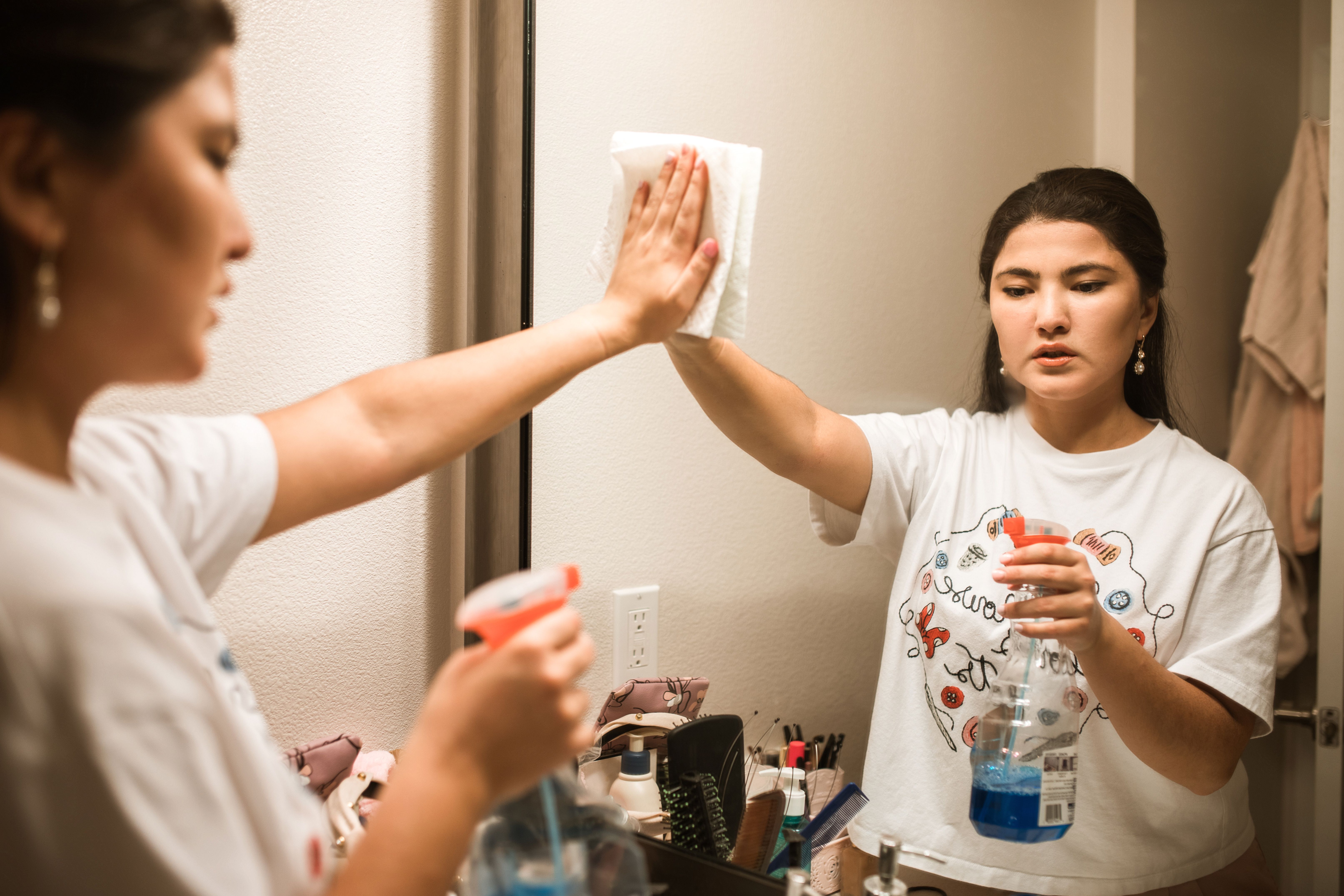 Professional cleaning service in NYC - a cleaner wiping down a bathroom mirror