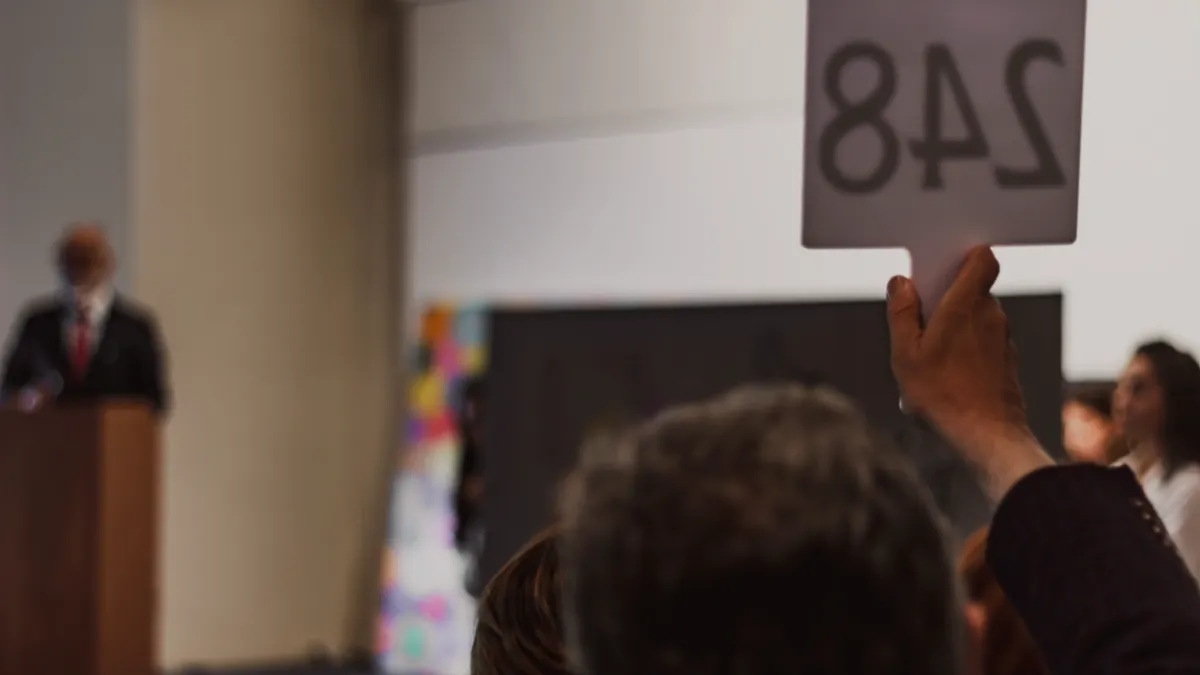 Person holding up a bid card at a fundraiser