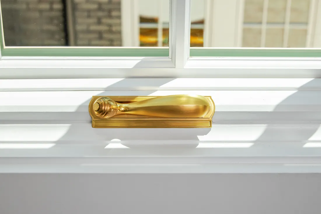 Bright brass elegant window hardware on luxury casement window