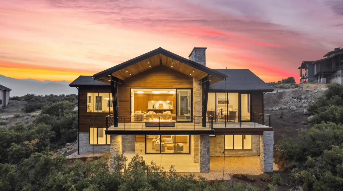 Modern luxury custom home nestled in Utah mountains at sunset