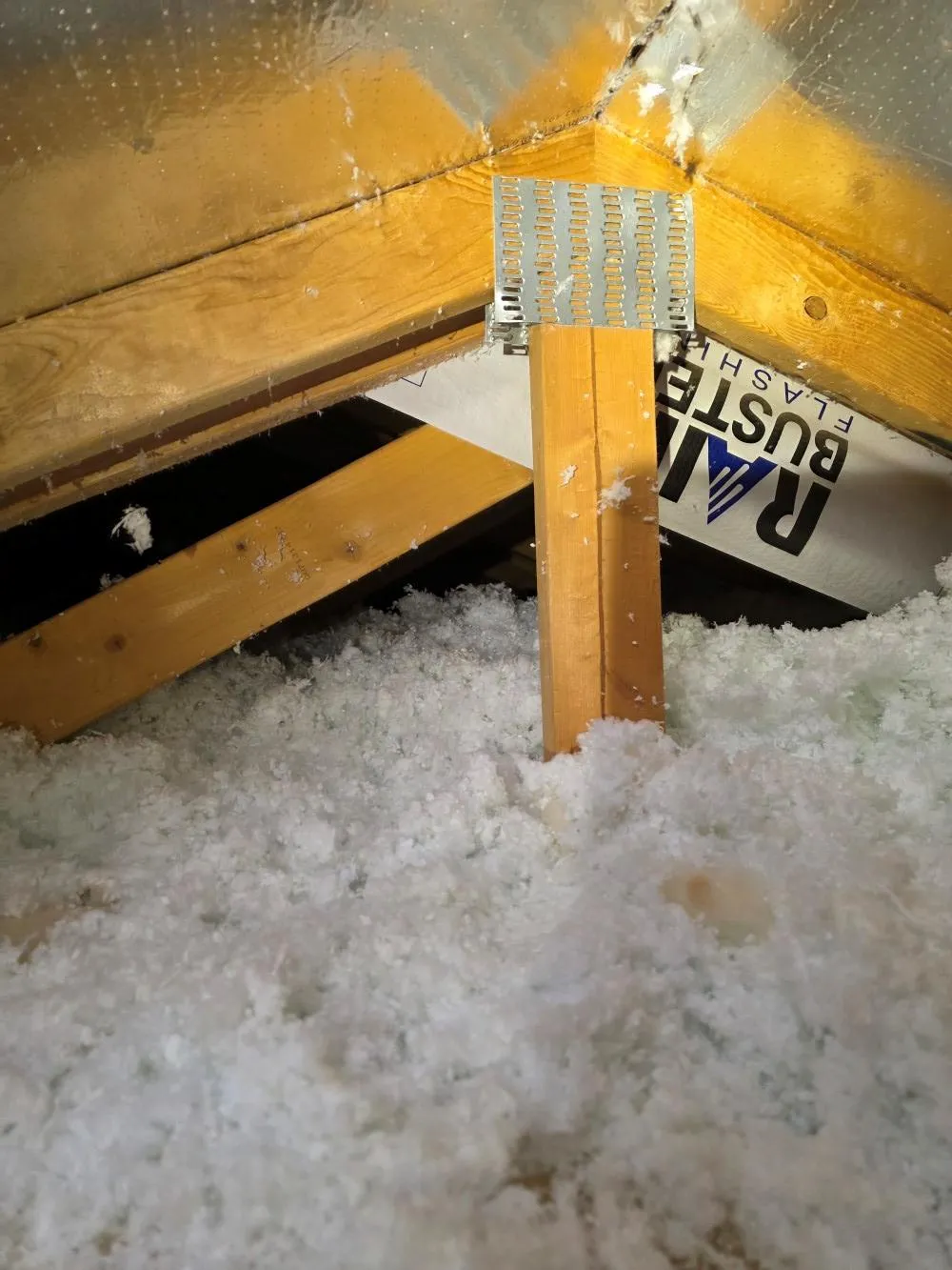 Professional insulation installer laying fiberglass insulation in Phoenix attic for improved home comfort and energy efficiency