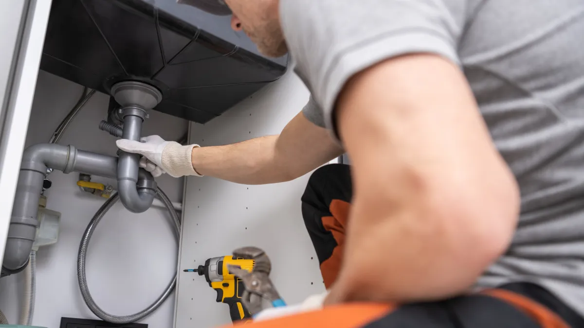 Plumber repairing a sink pipe