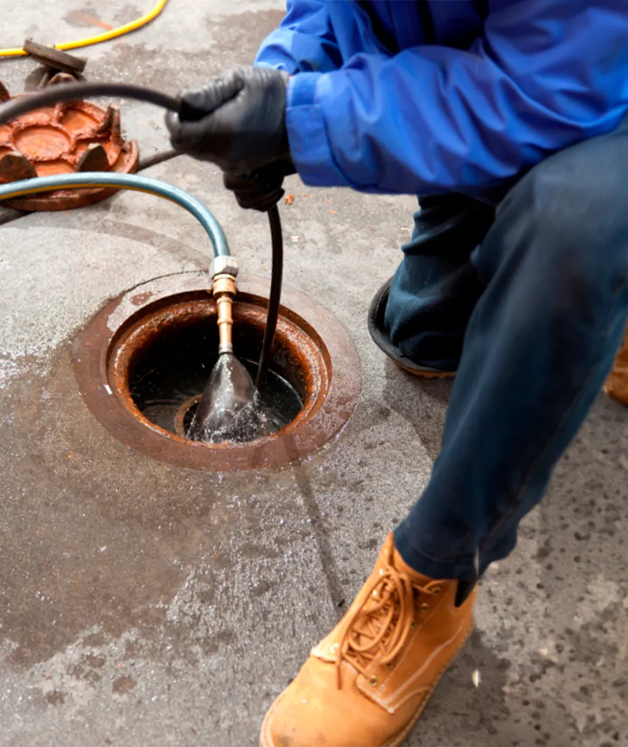 Man cleaning a sewer with specialized equipment to maintain urban drainage system