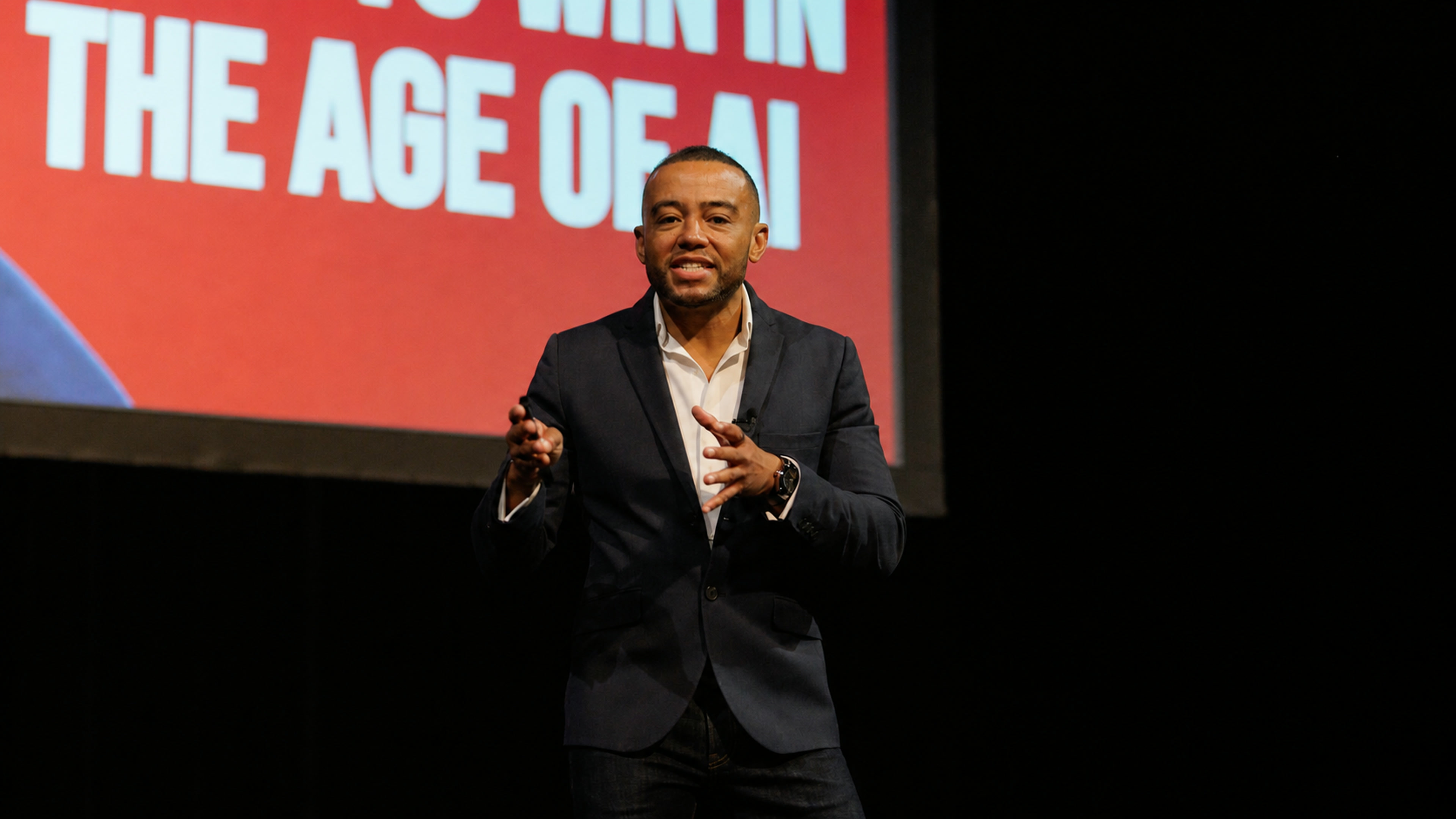 Ethan King on stage delivering an AI keynote to a business audience