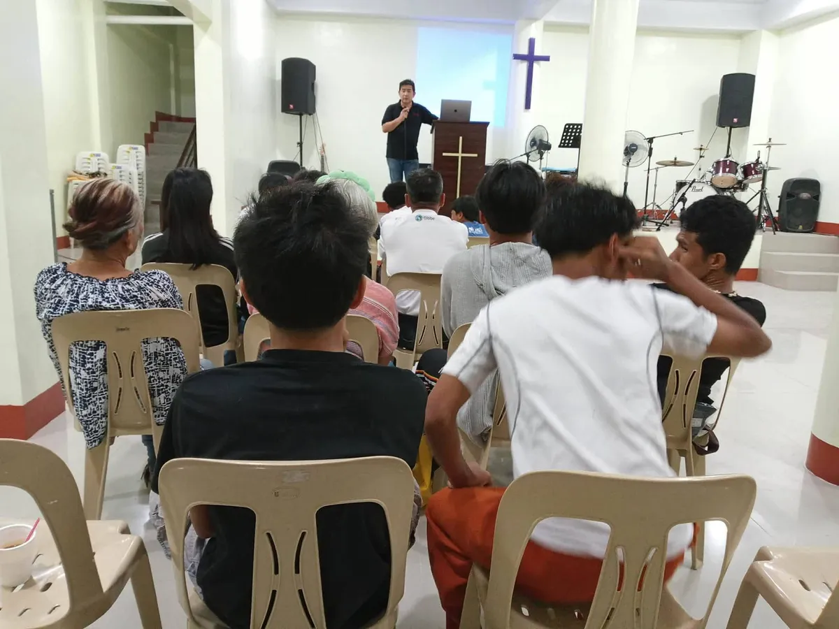 A warm, high-key photograph of church members deeply engaged in a community setting, with a subtle film grain effect.