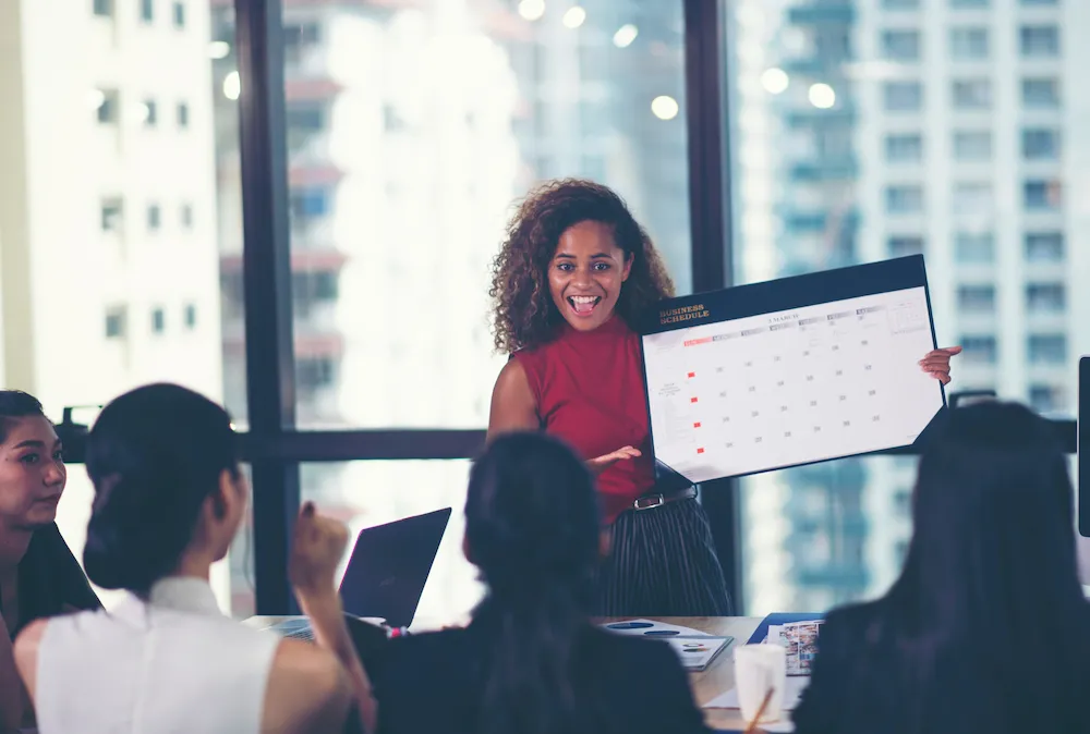 Woman presenting to colleagues in an in-person meeting