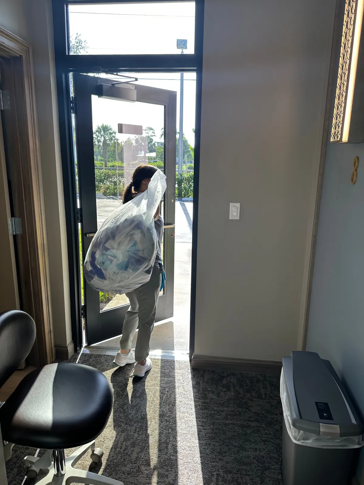 Cleaning staff taking out the garbage in commercial office, Collier county