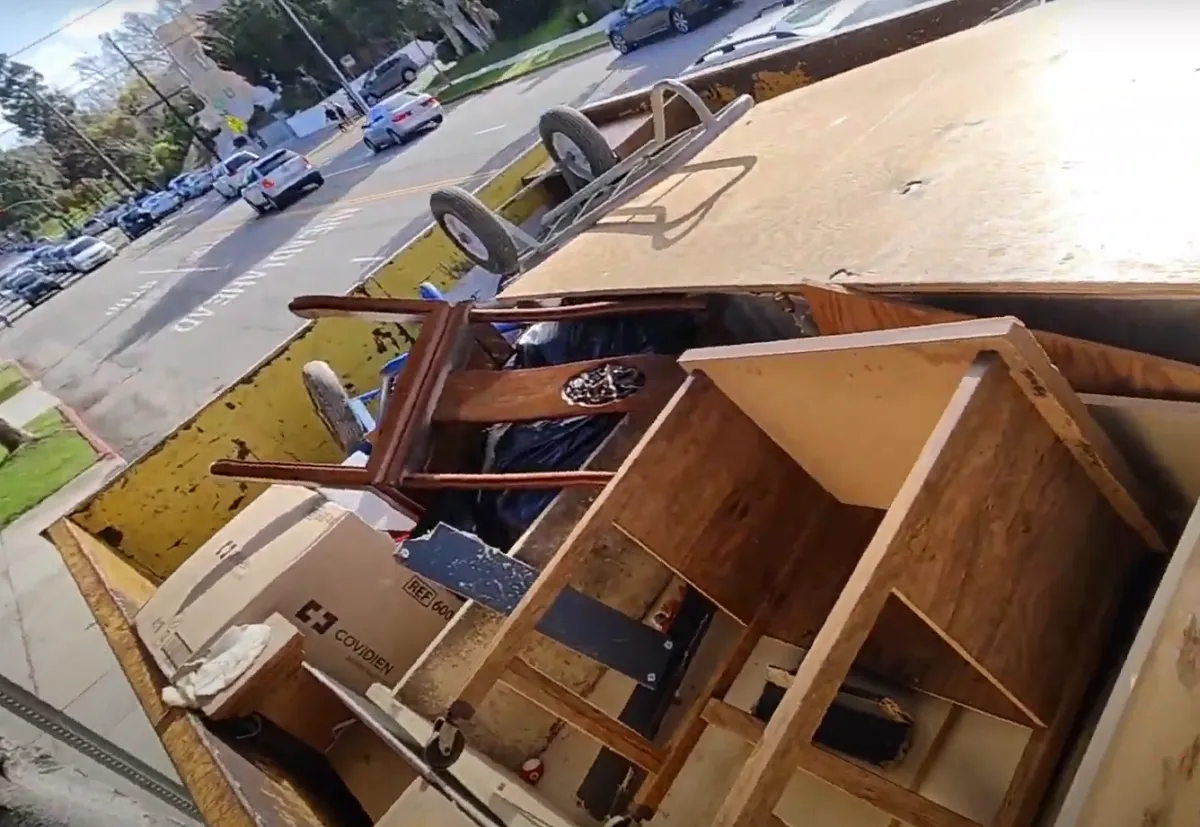 loaded tables, charis and other furniture on the top side of a truck