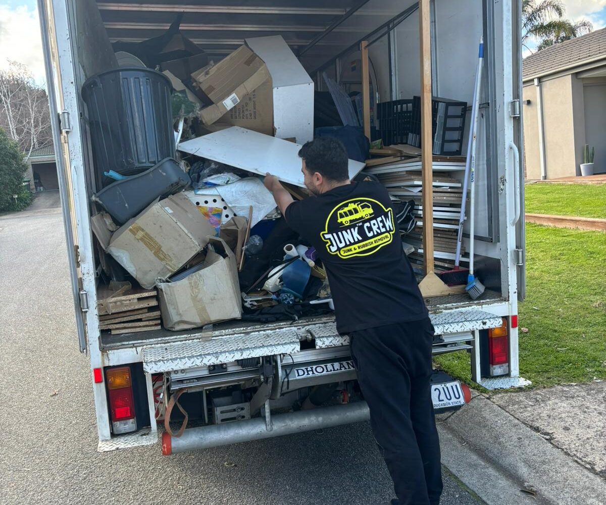 black shirt man loading junk into his truck