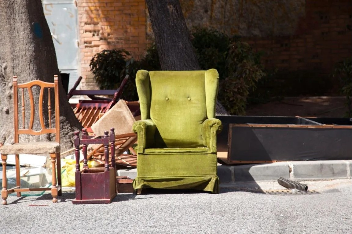 green cyan sofa with chairs and wood furniture on streetside curb