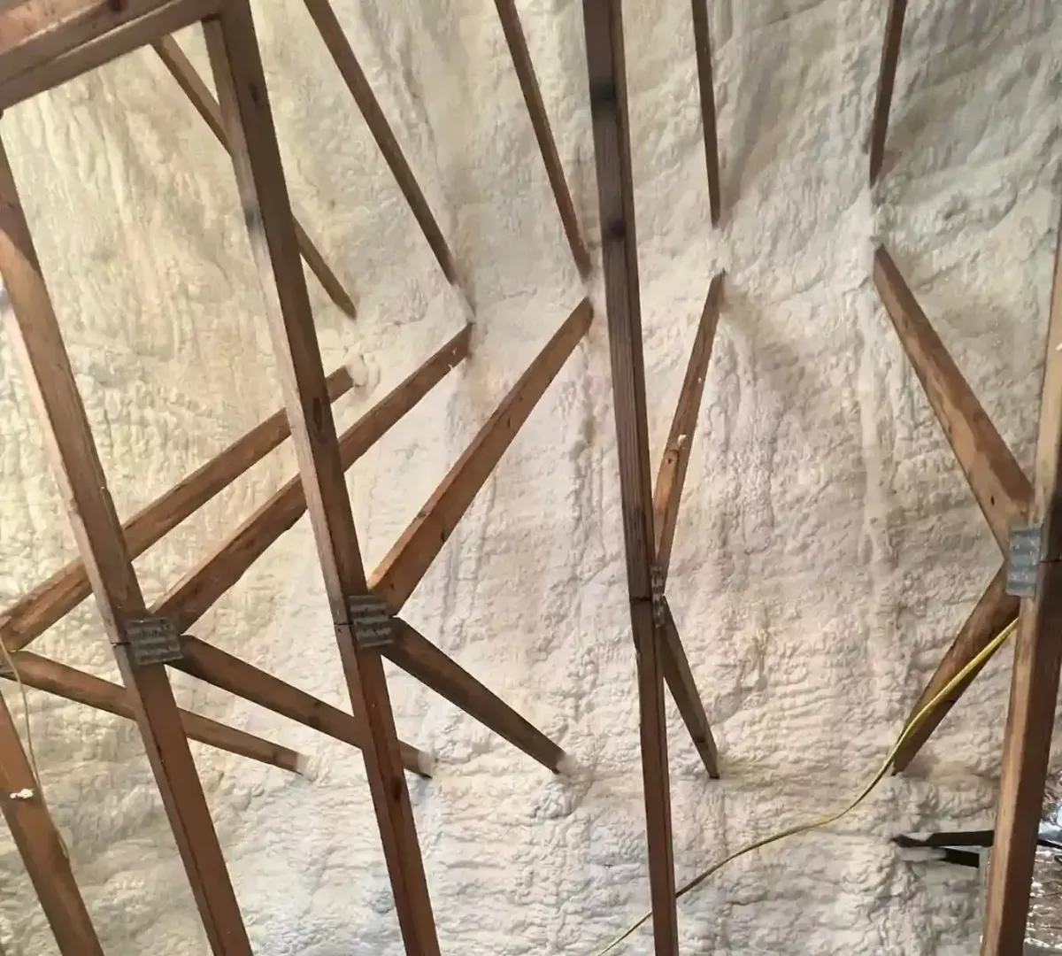 Closed cell spray foam applied to roof rafters in a Southport home for moisture protection strength and long term energy efficiency