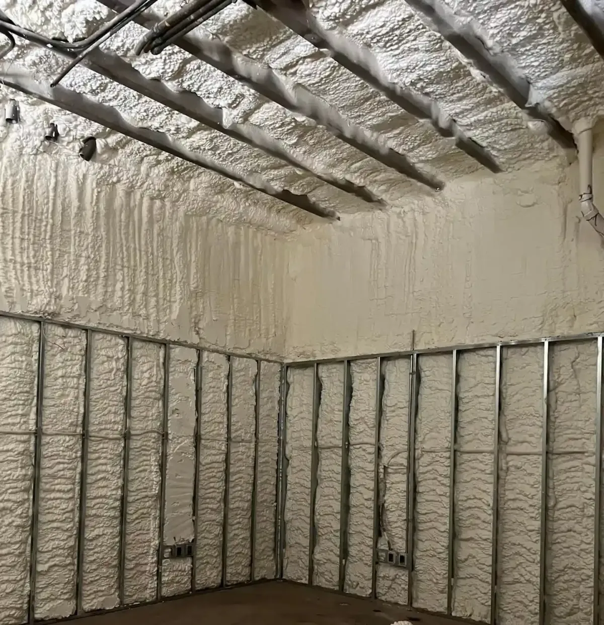 Open cell spray foam insulation applied on wall and ceiling framing in a residential project in Southport for improved energy efficiency and indoor comfort