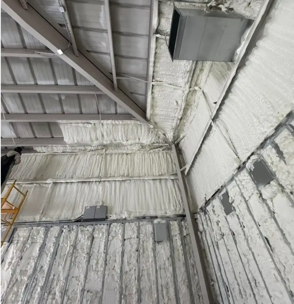 Blue Line Insulation applying closed cell spray foam on metal building walls and ceiling to enhance energy efficiency and structural durability