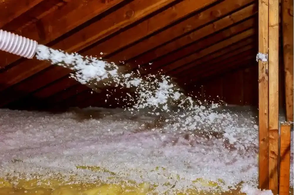 Blown-in fiberglass insulation filling attic floor in Port Saint Joe FL by Blue Line Insulation