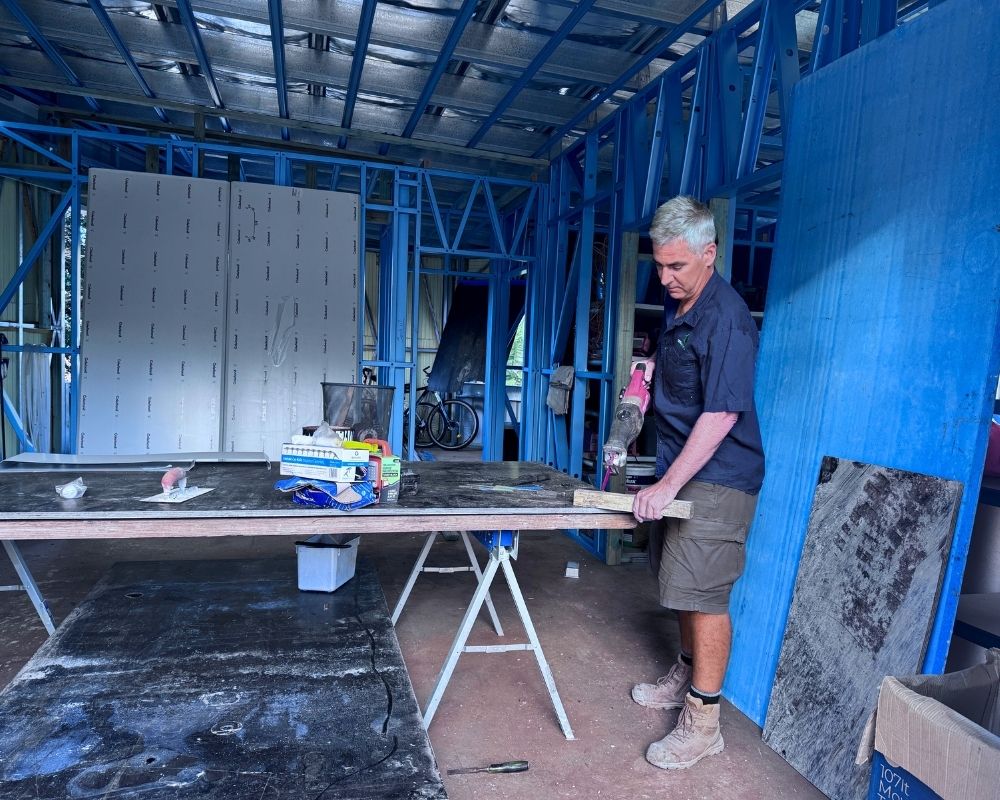 Builder Peter Mikus inspecting framing during a home renovation project