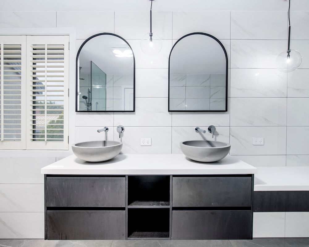 Renovated luxury bathroom with double vanity and frameless shower