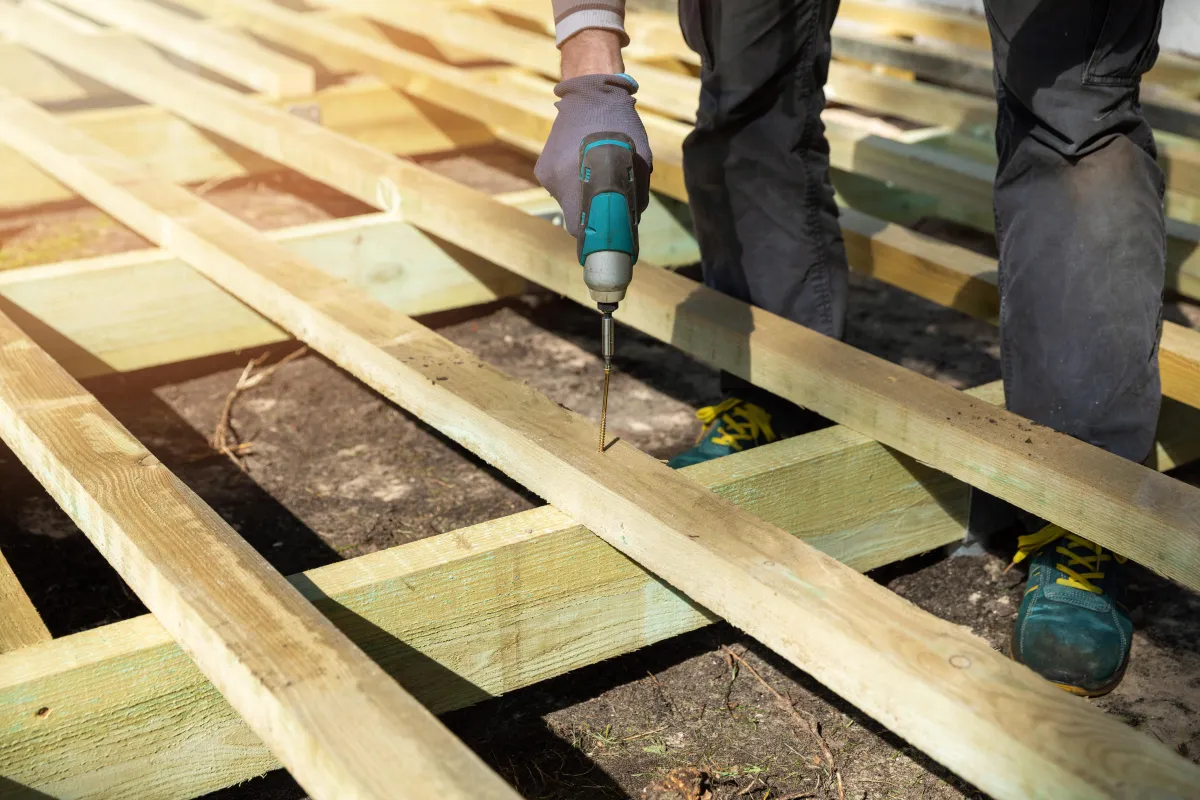 wWoden fence being assembled with an electric drill and screw during residential fencing installation
