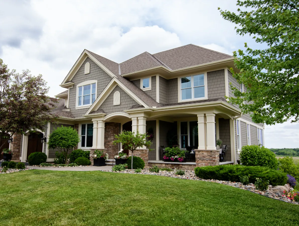 Custom built Florida home with front porch, gabled roof, and landscaped yard by Dream Design Building Group