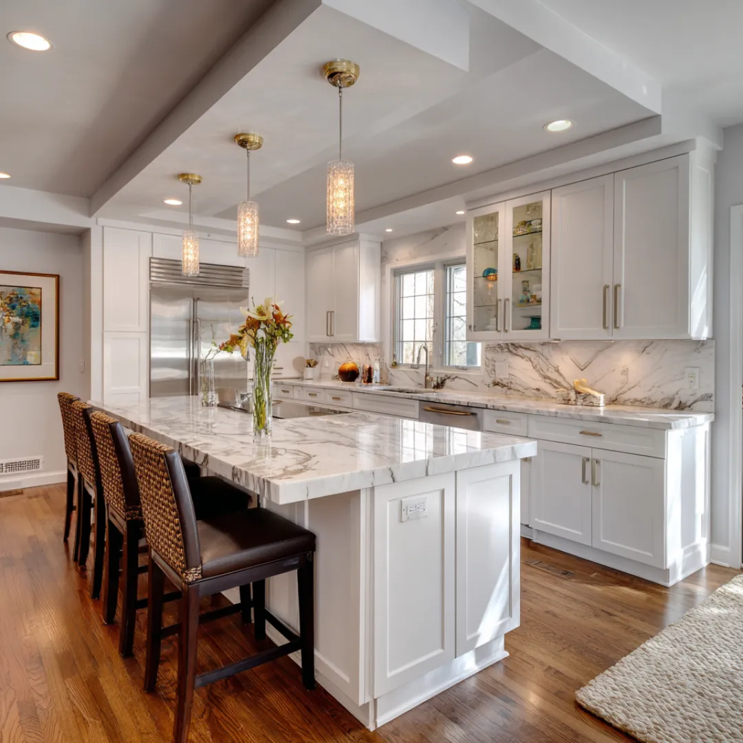 Luxury kitchen renovation with marble island, pendant lighting, and white cabinetry designed by Dream Design Building Group