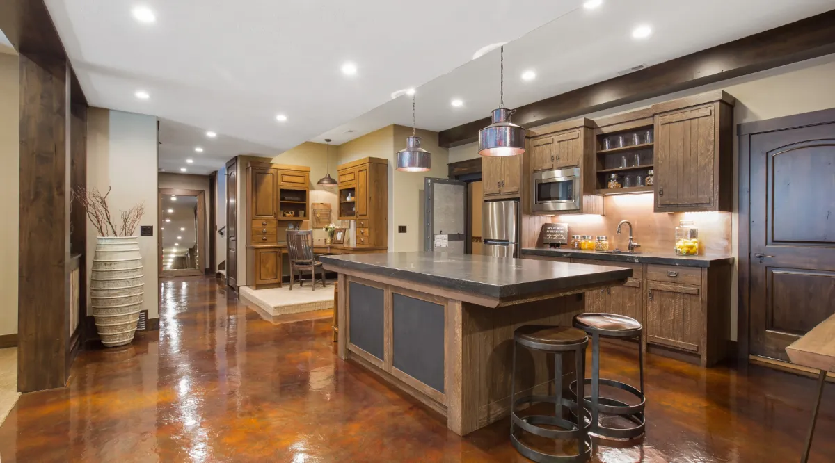 Home remodeling project featuring rustic kitchen design with wood cabinetry, large island, and polished concrete floors by Dream Design Building Group Jacksonville
