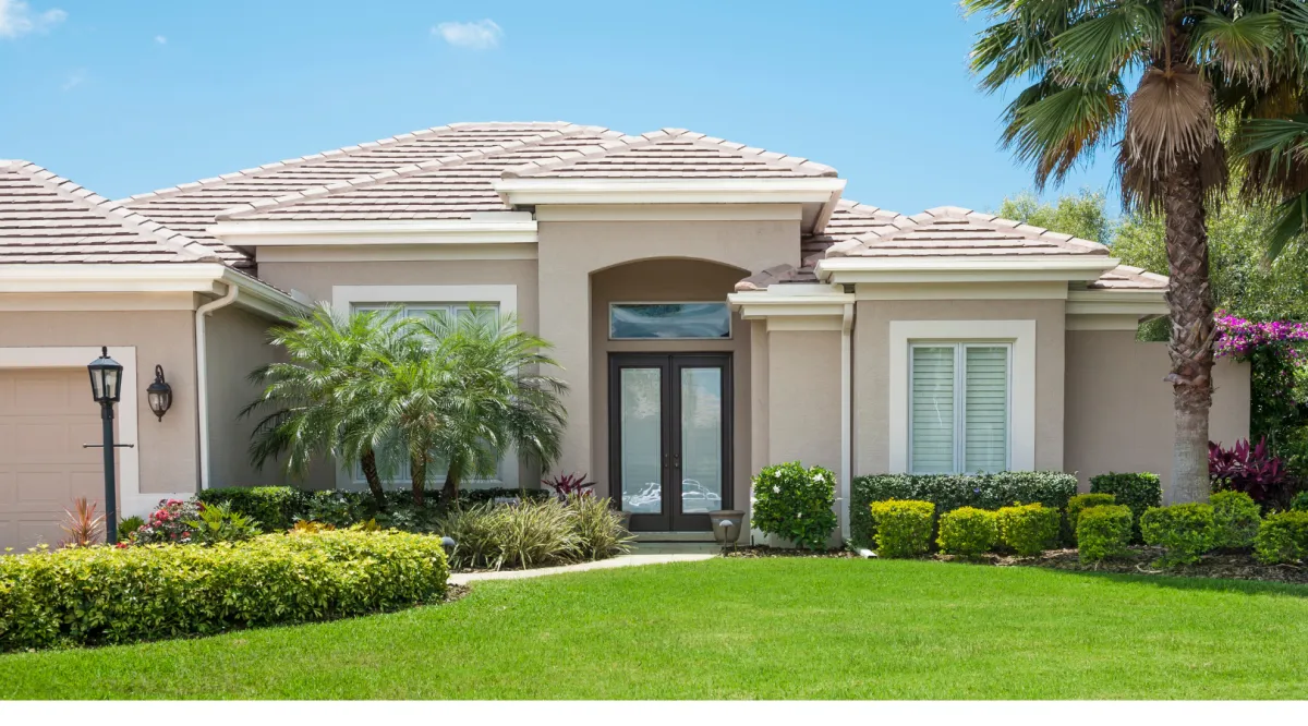 Custom Florida home exterior with stucco finish, palm trees, and landscaped yard built by Dream Design Building Group Jacksonville