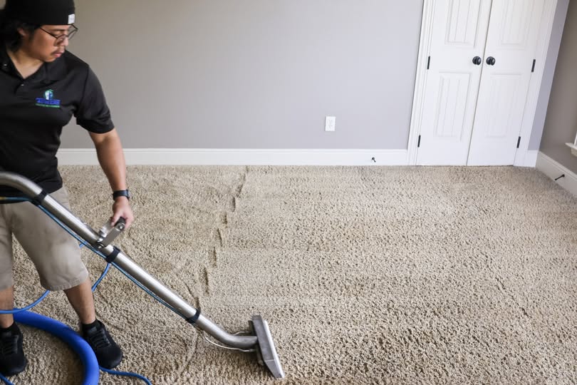 Photo of a man steam cleaning carpets