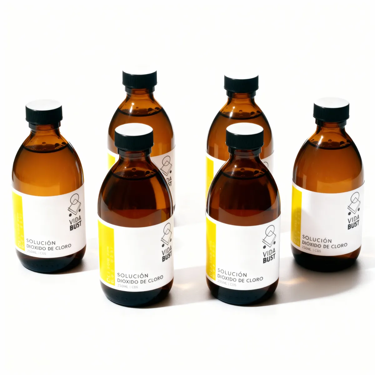 A close-up of the two Dr. Kalcker books stacked beside six upright CDS bottles, all on a light wooden surface with a soft yellow background, conveying warmth and approachability. No people are present.