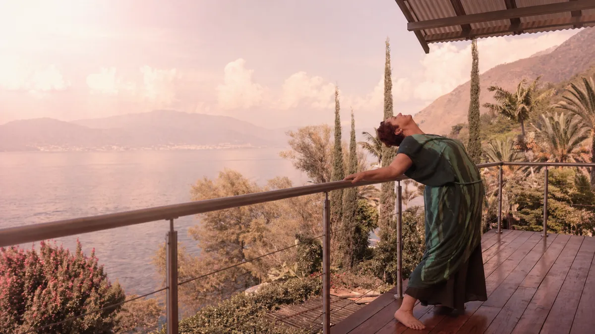 Val practicing somatic bodywork on a peaceful lakeside balcony
