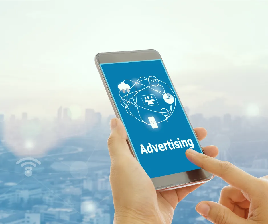 Person holding a smartphone displaying digital advertising graphics, representing Facebook and Google Ads services.