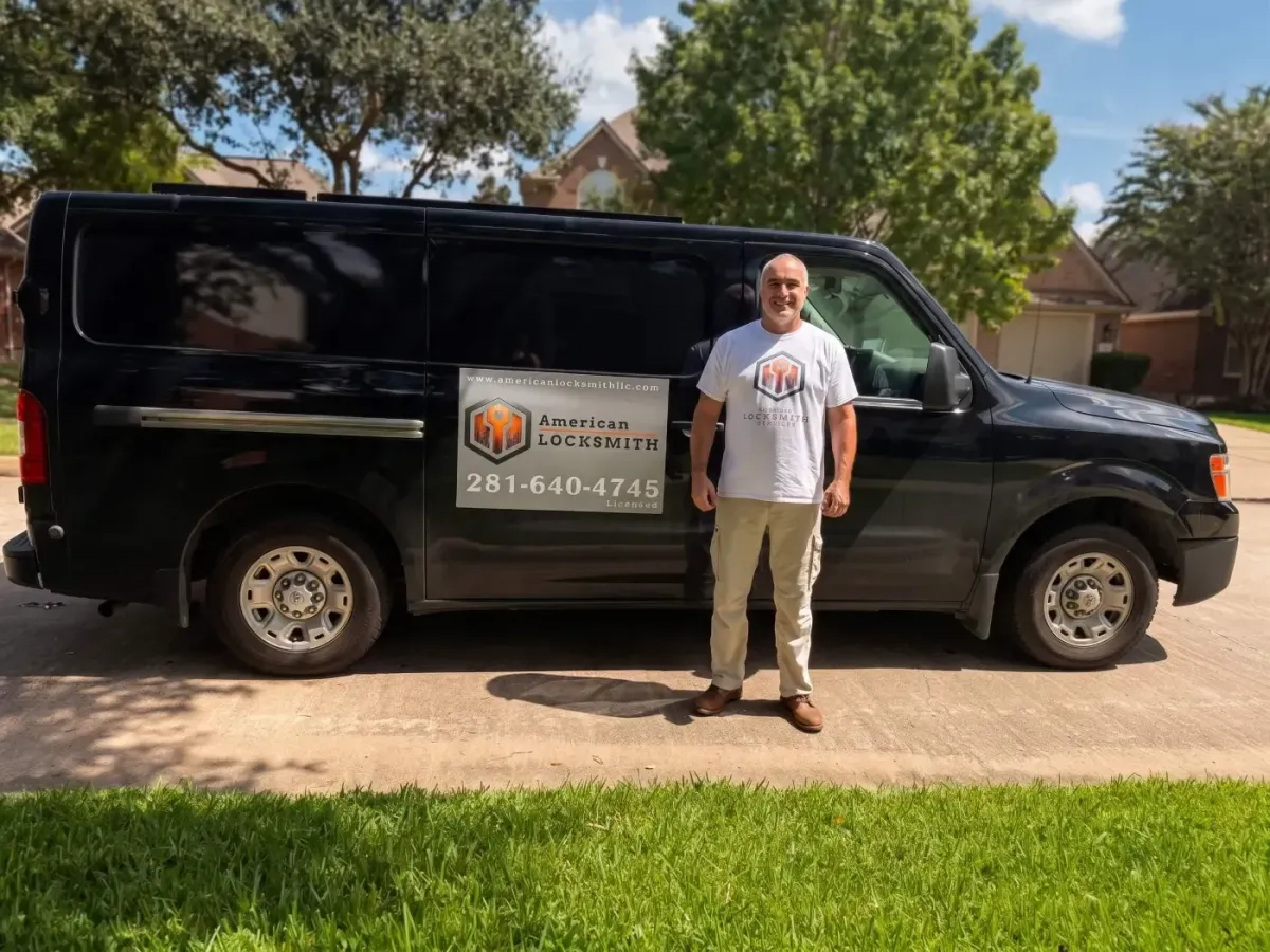 Alexey, owner of American Locksmith Services, standing beside his black work van with the American Locksmith sign and phone number 281-640-4745
