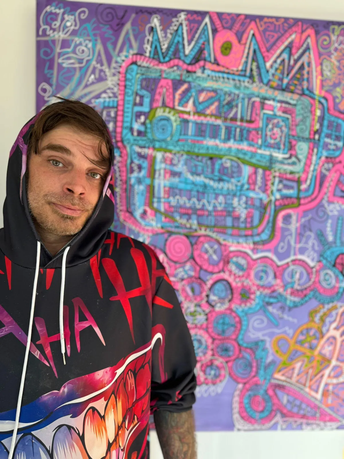 Sven Liesy, deutscher Neo-Expressionist, vor einem seiner farbintensiven Acrylgemälde: zeitgenössische Kunst voller Symbole, Muster und dynamischer Linien.