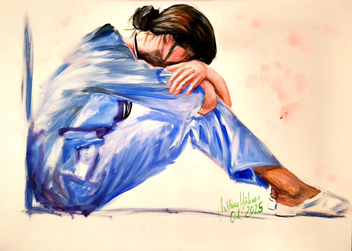 Sitzende Figur in blauer Kleidung, Kopf auf verschränkten Armen vor hellem Grund – ‚Fertig‘ von Matthias Hübner (2025).