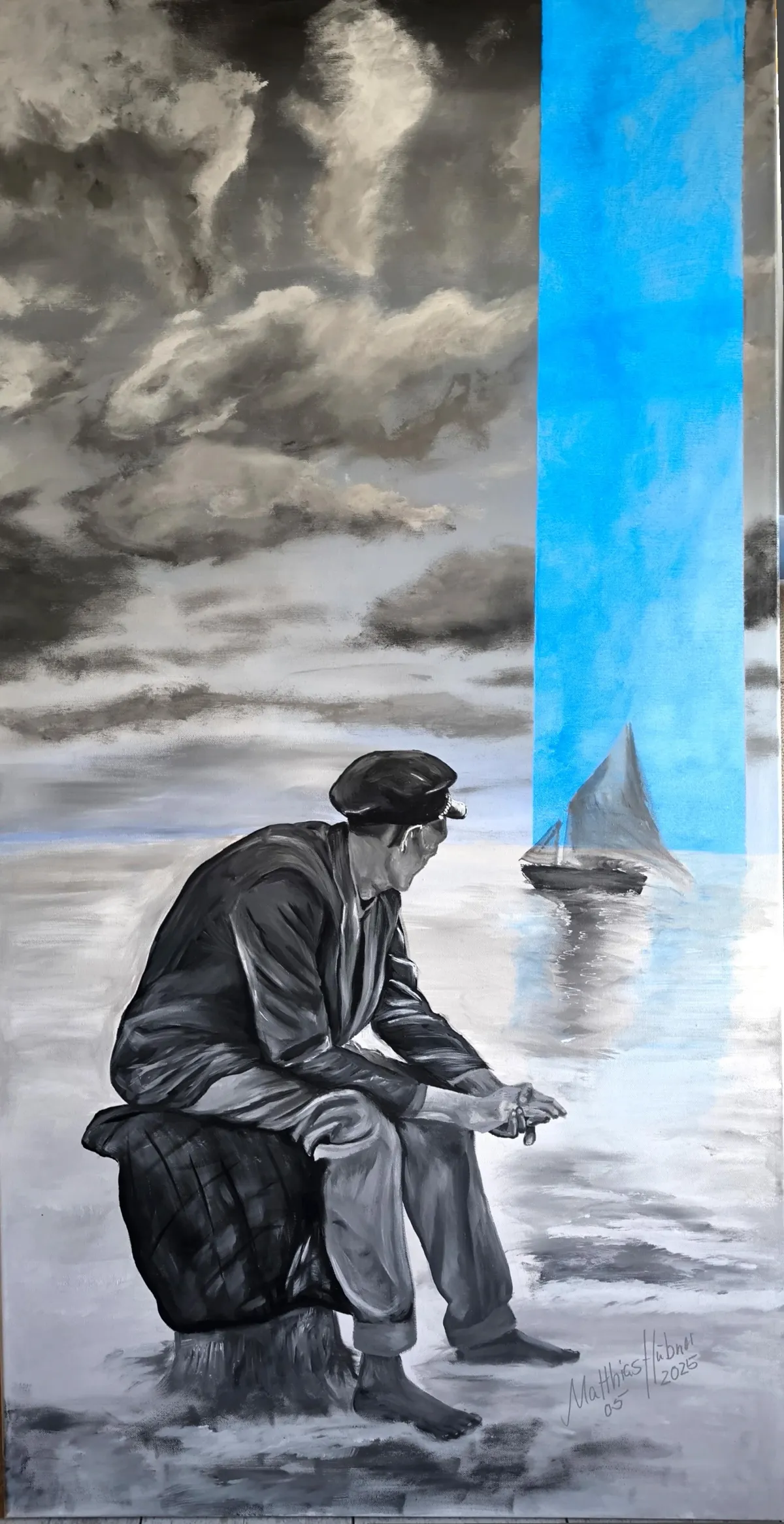 Monochrome Küste mit sitzendem Mann, der zu einem Segelboot blickt; ein vertikales, leuchtend blaues Farbfeld öffnet den Horizont – ‚Zu Hause‘ von Matthias Hübner (2025).