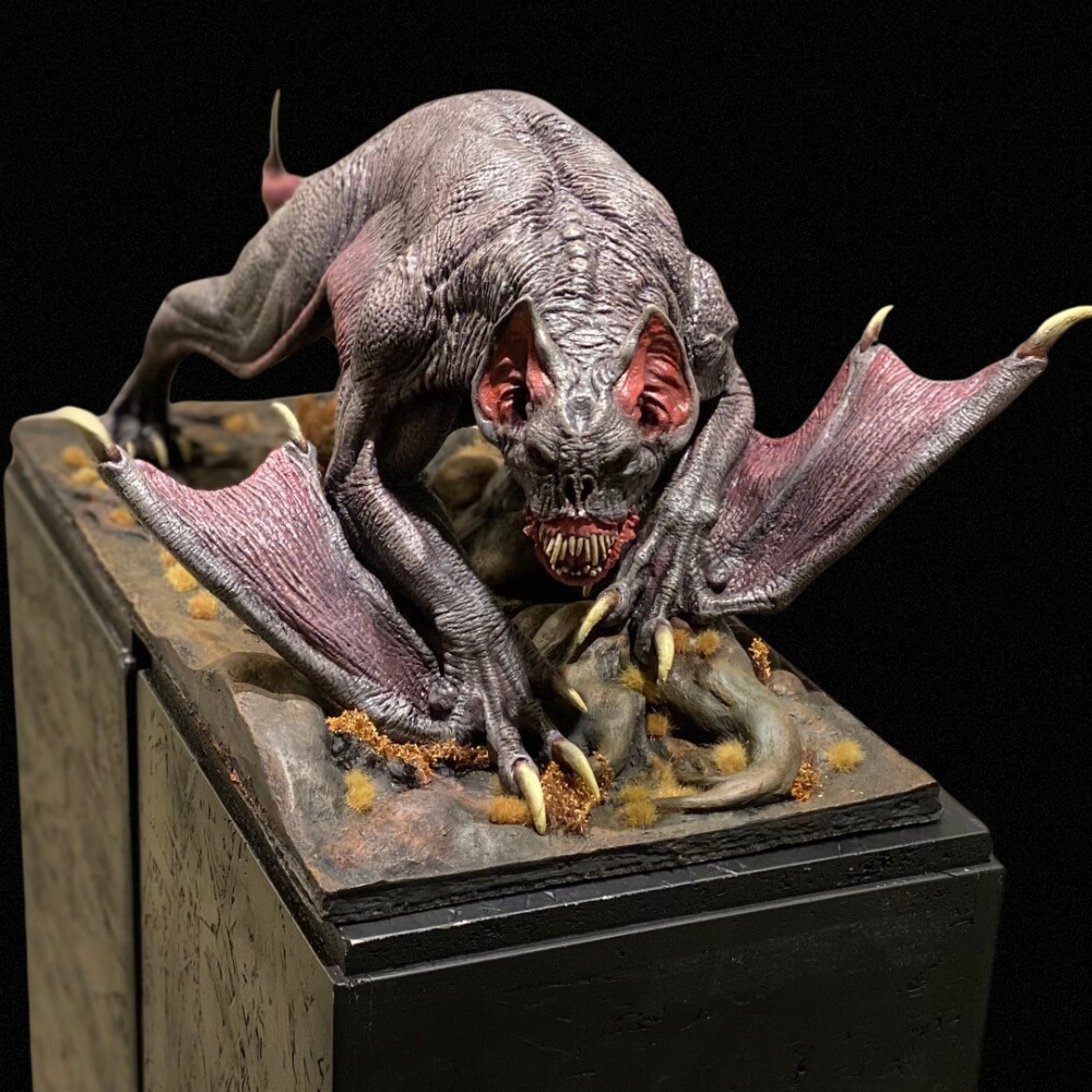 Batcat Skulptur von Winton Afrić – detailreich modelliertes, fledermausartiges Kreaturenwesen mit aufgerissener Schnauze und Krallen auf Diorama-Podest vor schwarzem Hintergrund.