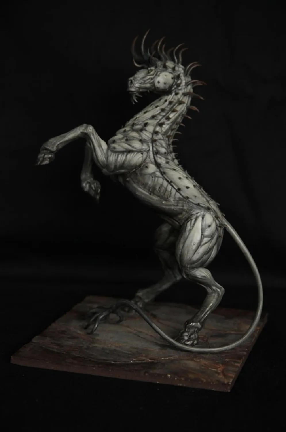 Keras – Unikat-Kunstskulptur von Winton Afrić: aufbäumende, pferdeähnliche Kreatur mit Dornreihe aus Resin (Kunstharz) auf Basis, vor schwarzem Hintergrund.