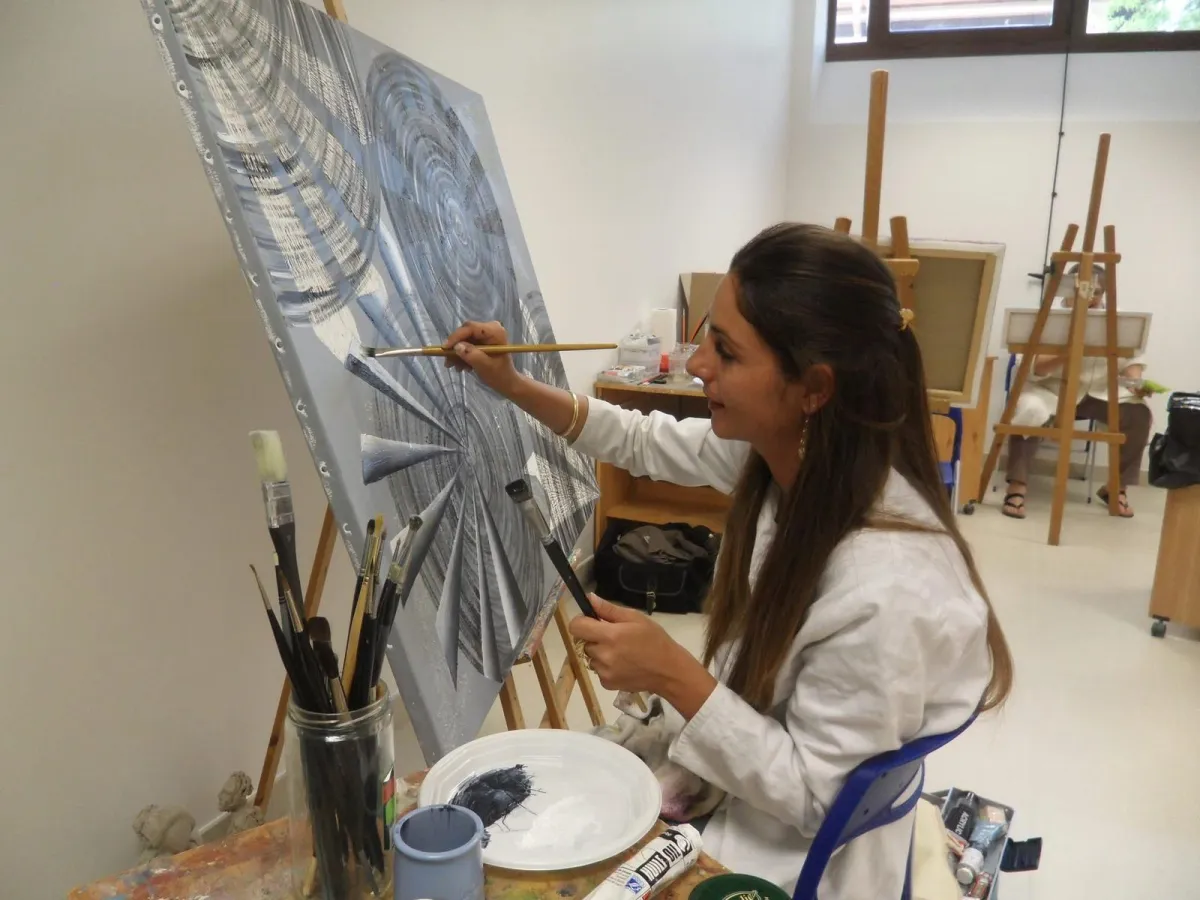 Christie Marangio en pleine création dans son atelier, réalisant une peinture abstraite contemporaine sur toile.