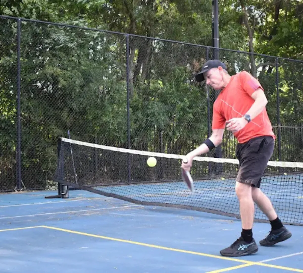 older man playing singles pickleball tournament