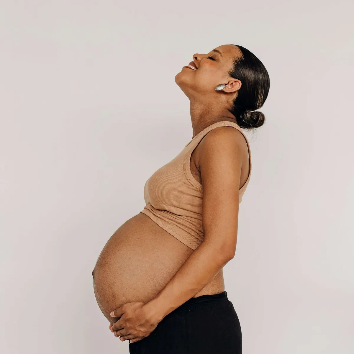 A pregnant woman cradling her bump