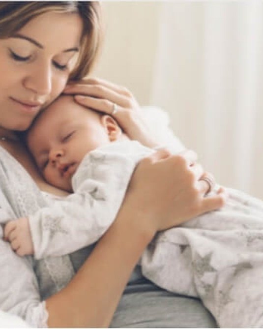 A mother holding her sleeping baby