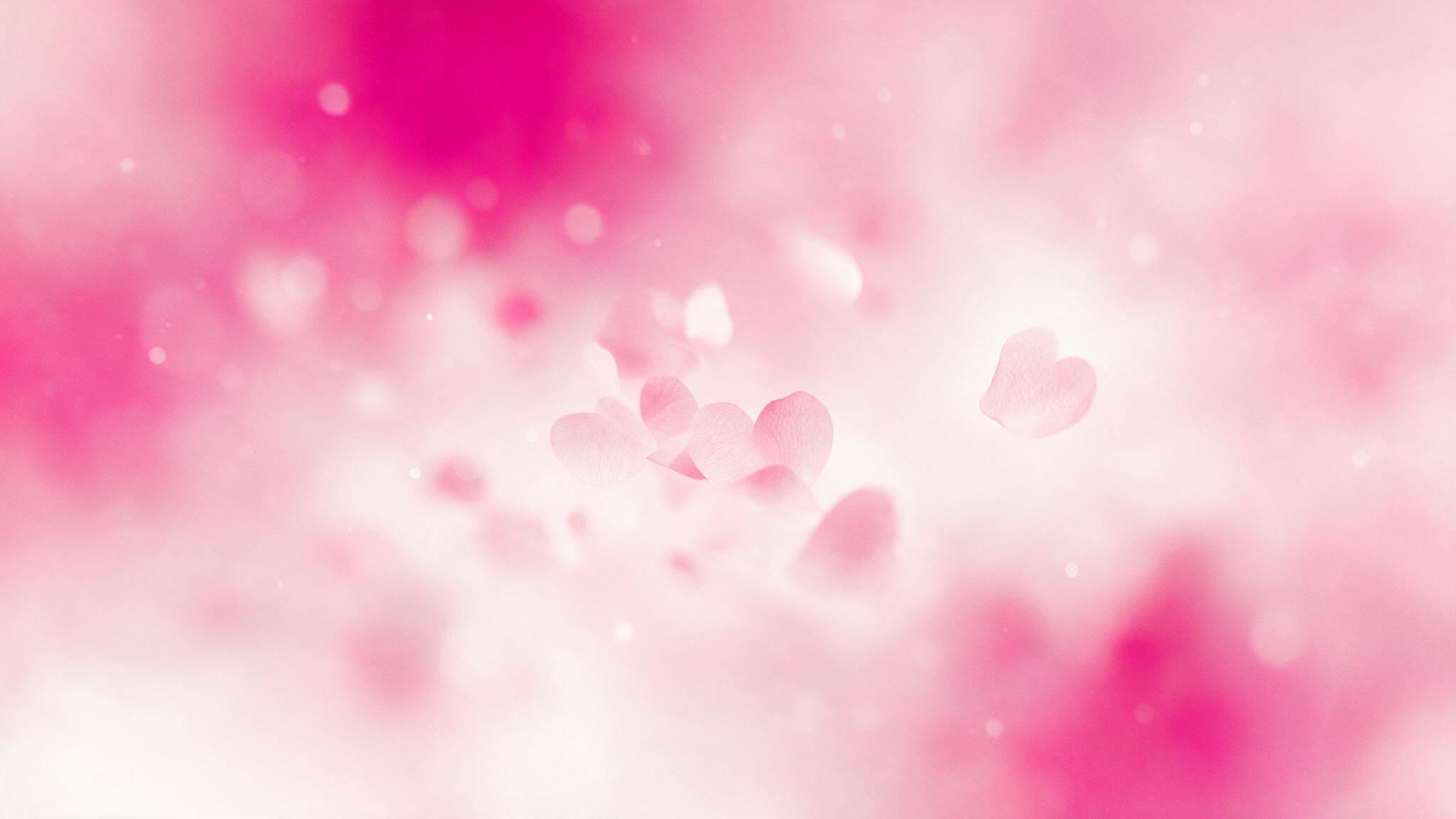 Formes de cœurs roses floutés sur fond rosé apaisant, l'un légèrement à l'écart — illustration du breadcrumbing en amour
