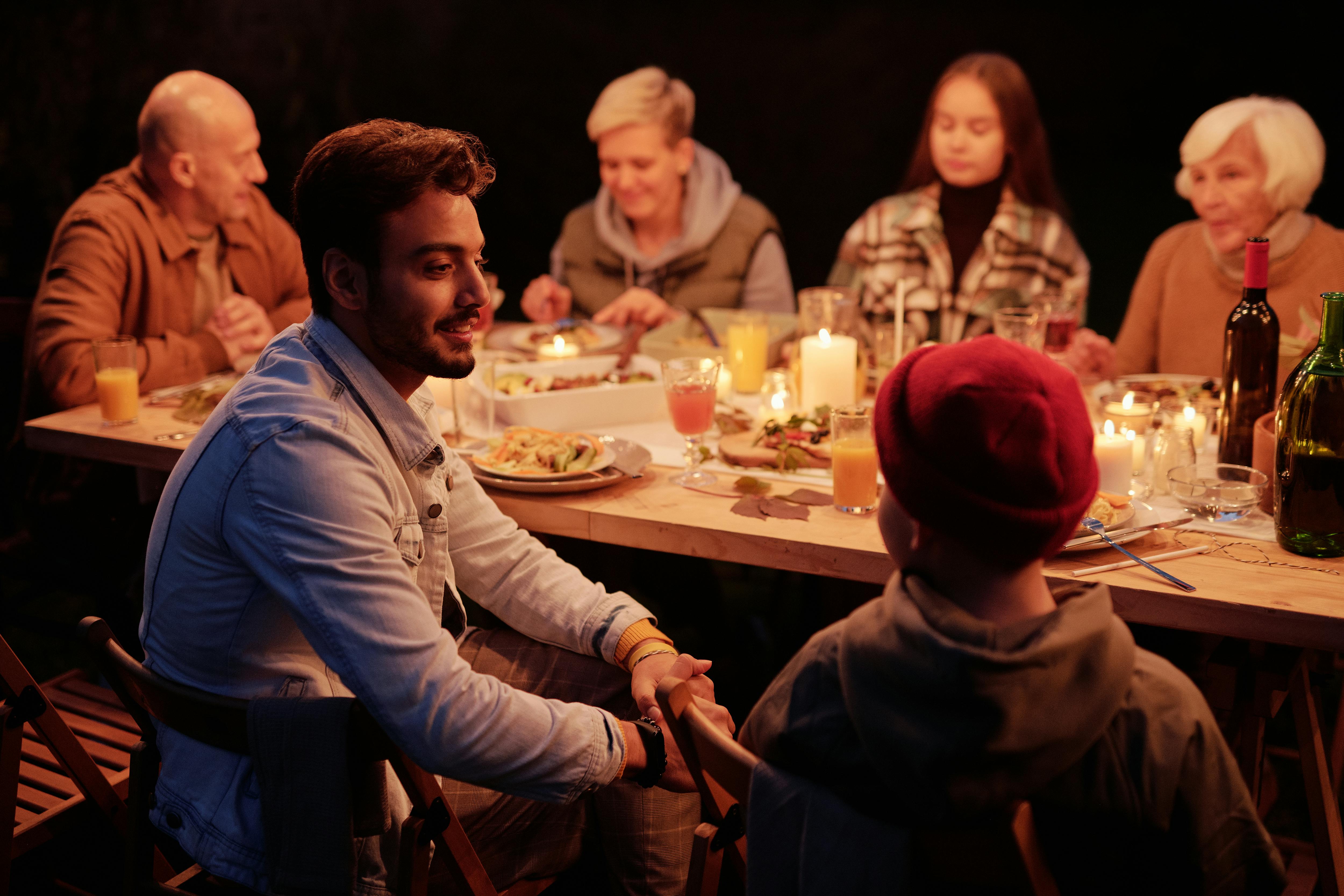 multi-generational family eating a meal at a candle-lit dinner